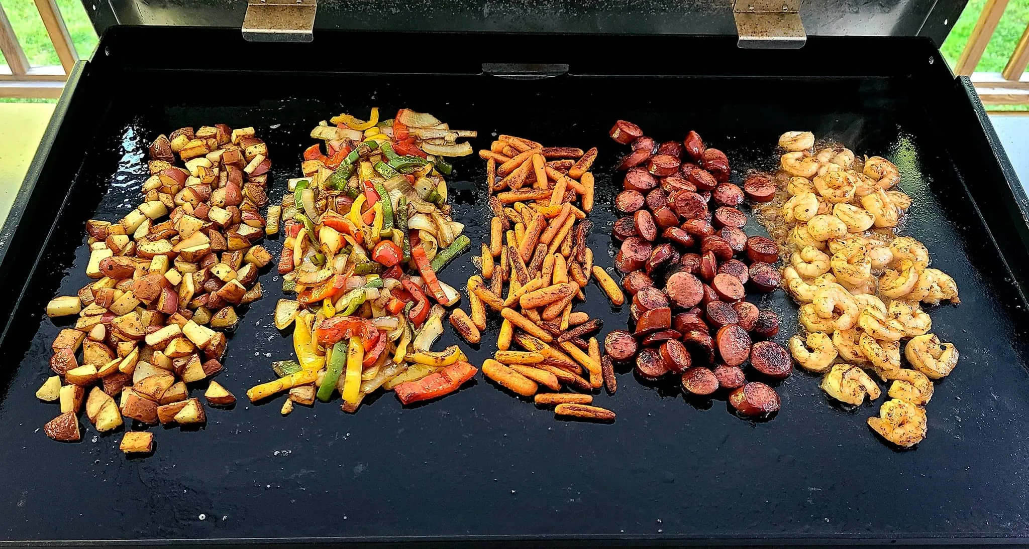 Blackstone 36" griddle with multiple foods cooking across zones