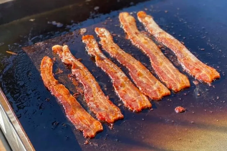 Blackstone griddle bacon cooking at medium-high heat