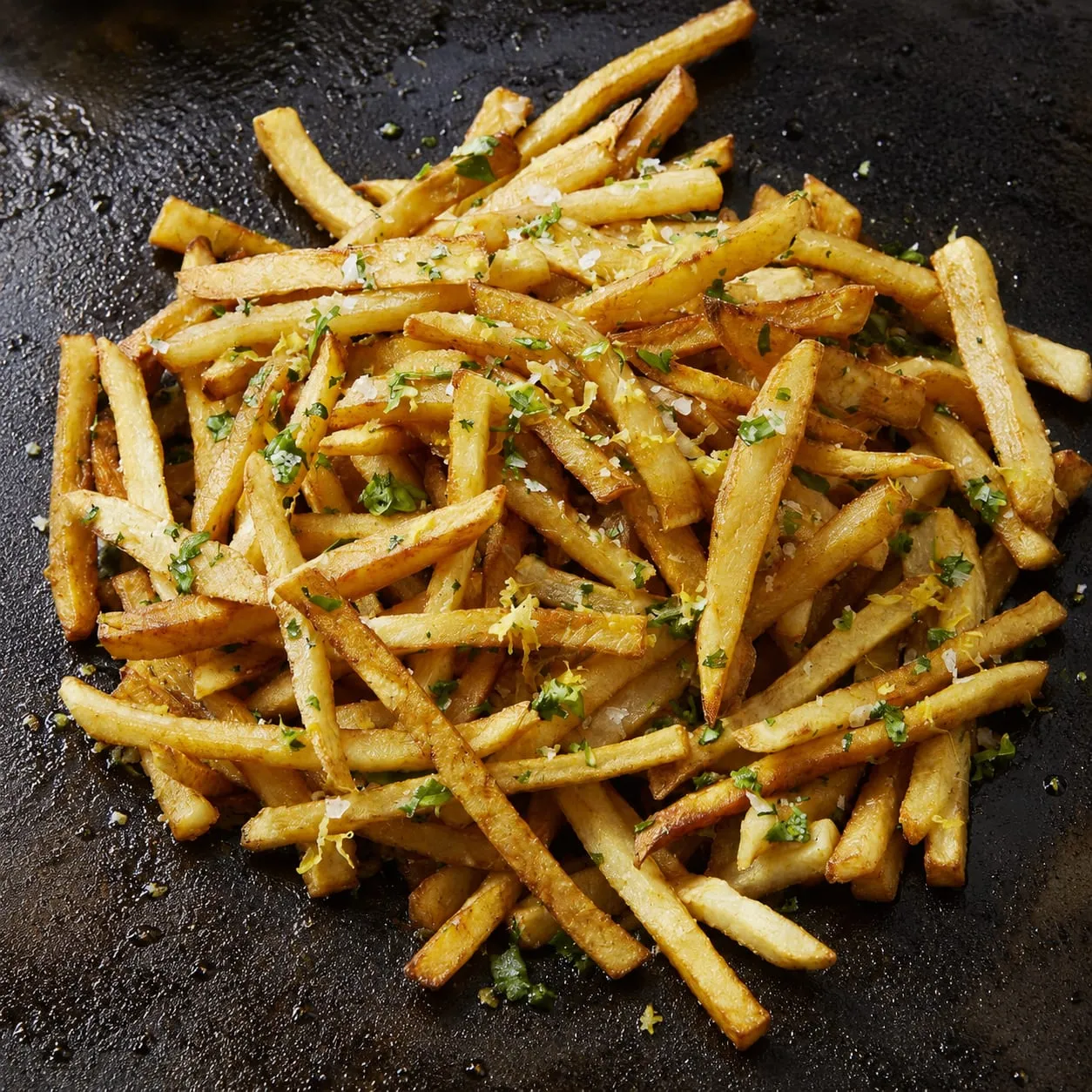 Crispy golden french fries cooking on a Blackstone flat-top griddle