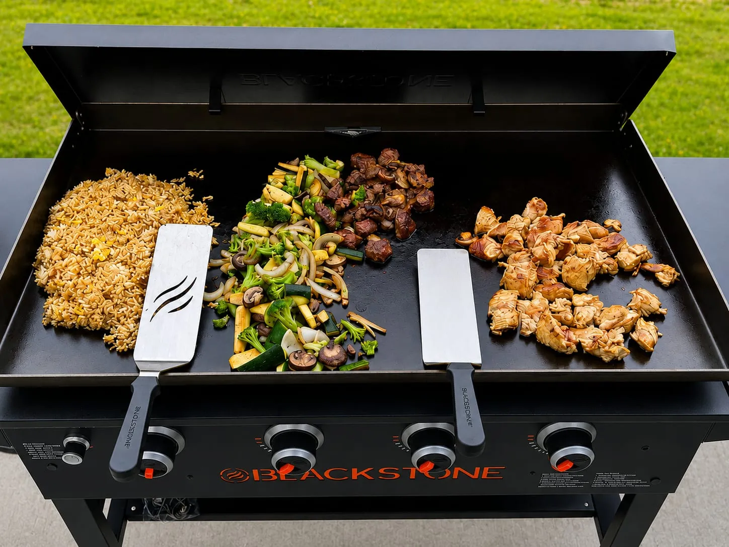 Blackstone hibachi chicken with garlic butter, fried rice, and stir-fried vegetables on the flat-top