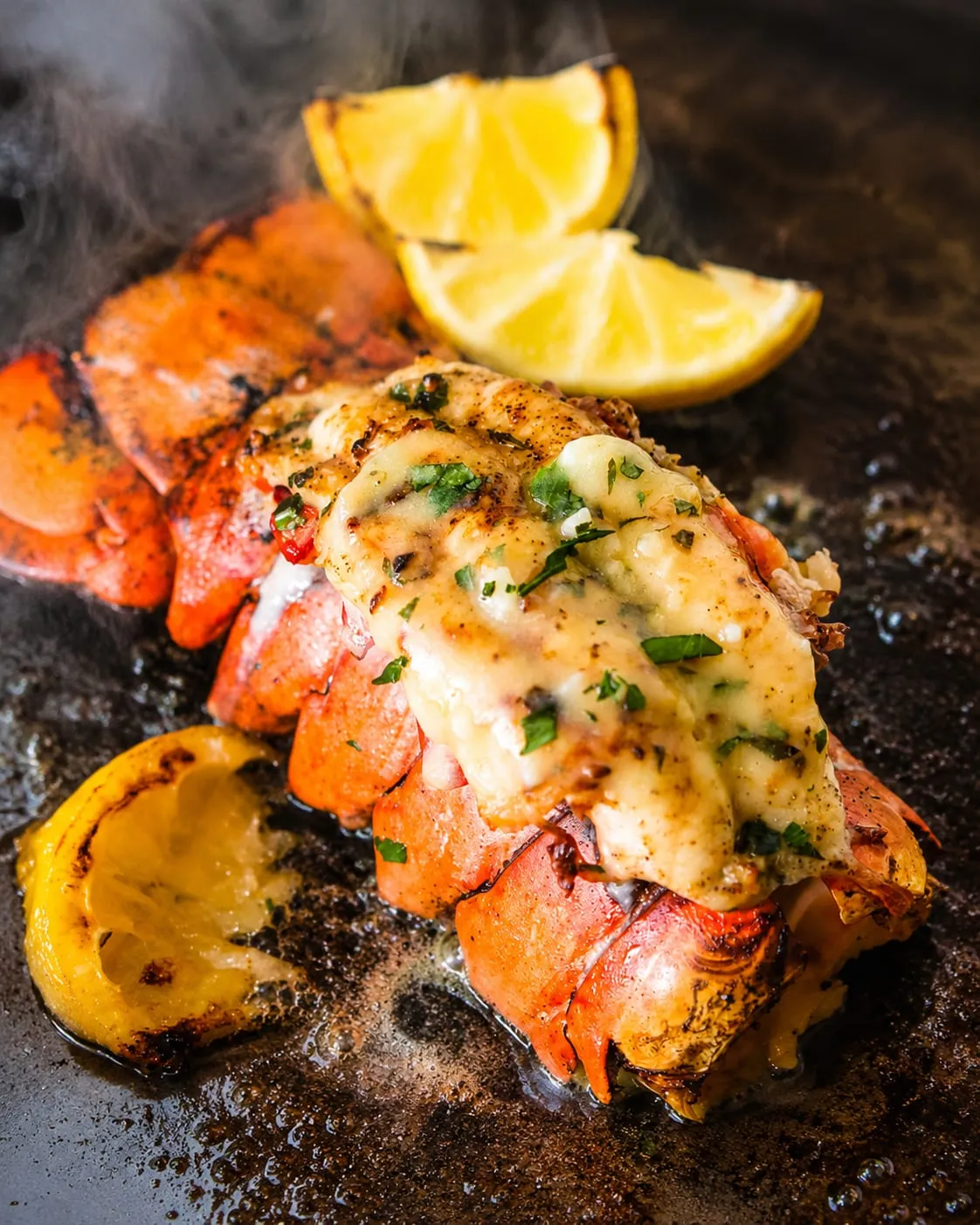 Butter-basted lobster tail cooking shell-side down on a Blackstone griddle
