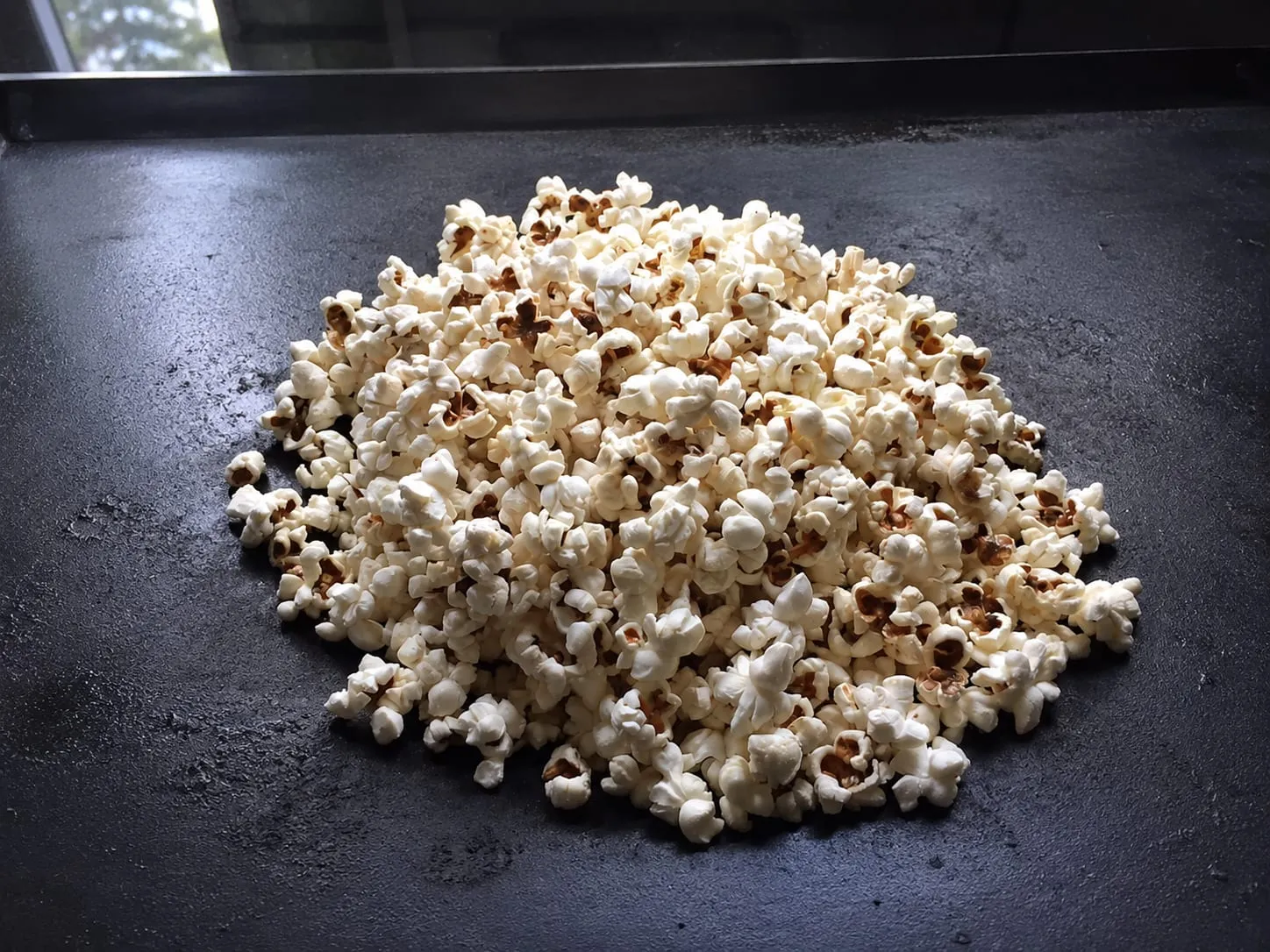 Popcorn popping in a heavy pot on a Blackstone griddle
