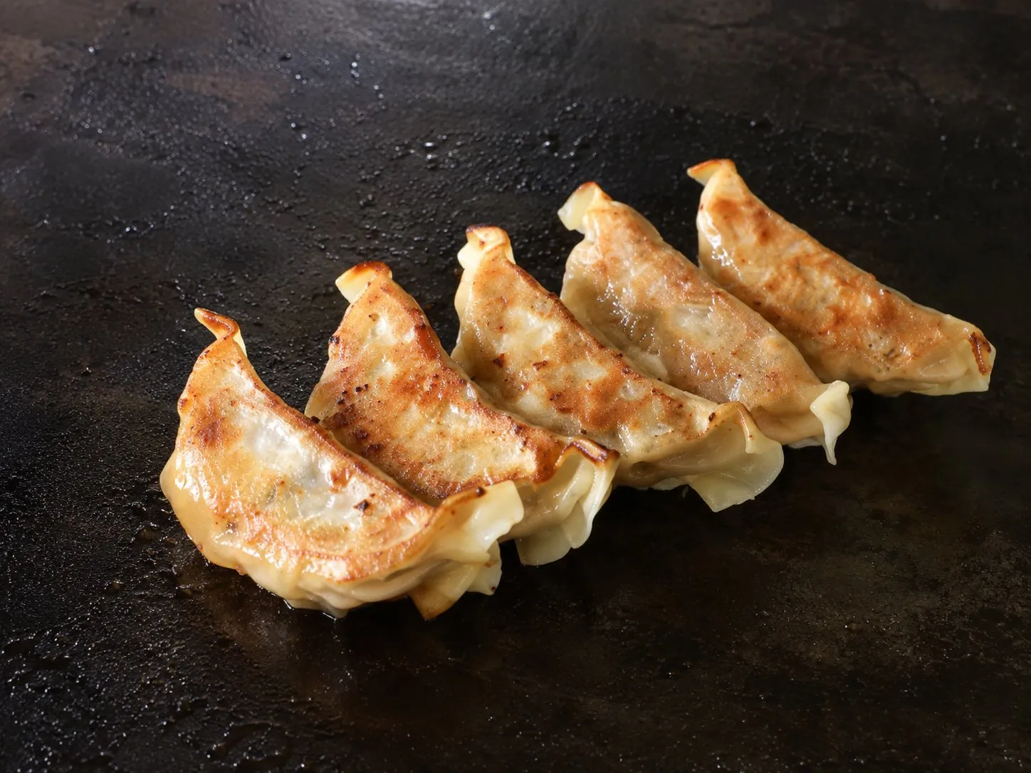 Golden seared potstickers on a Blackstone griddle