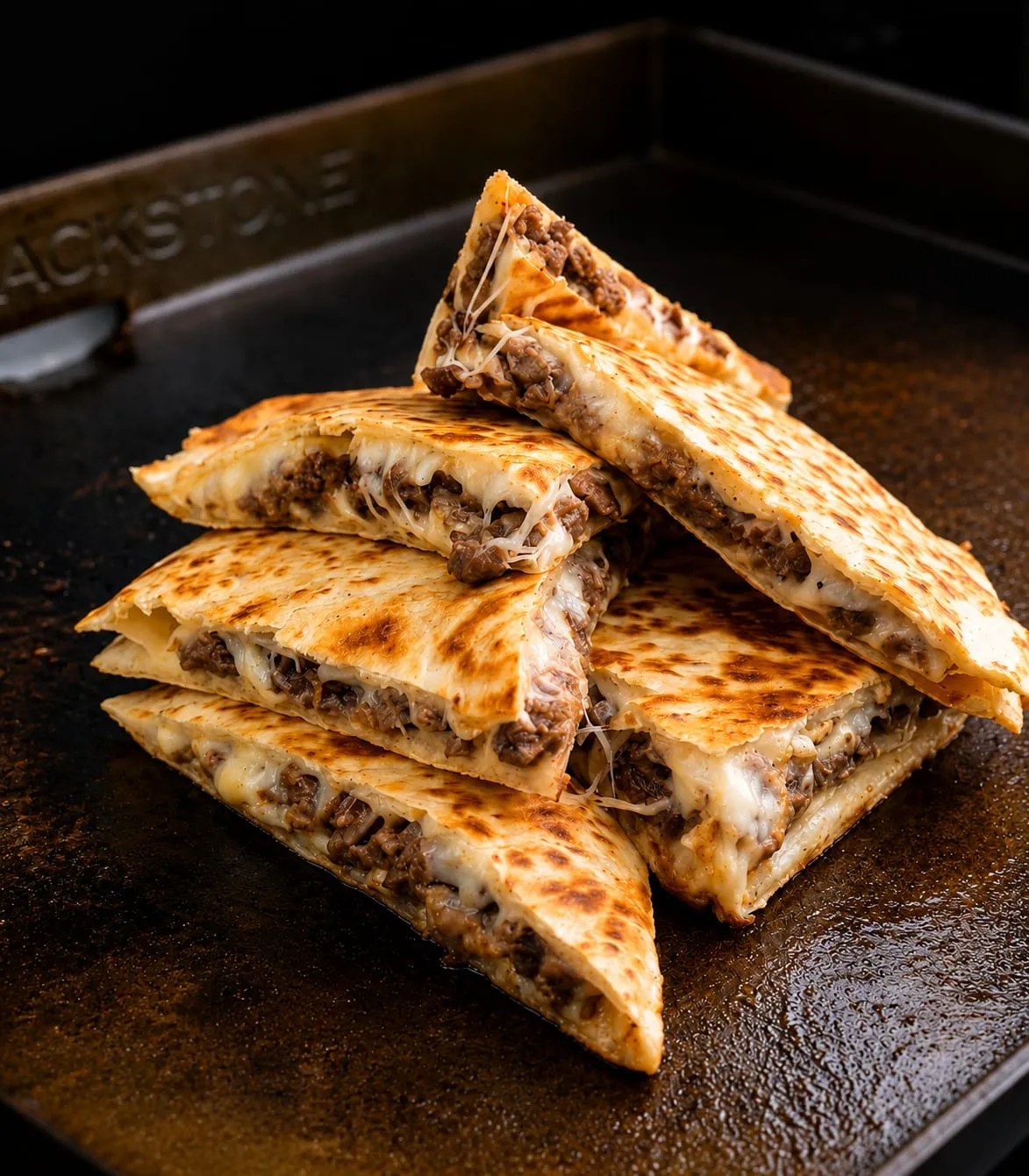 Crispy quesadillas cooking on a Blackstone griddle