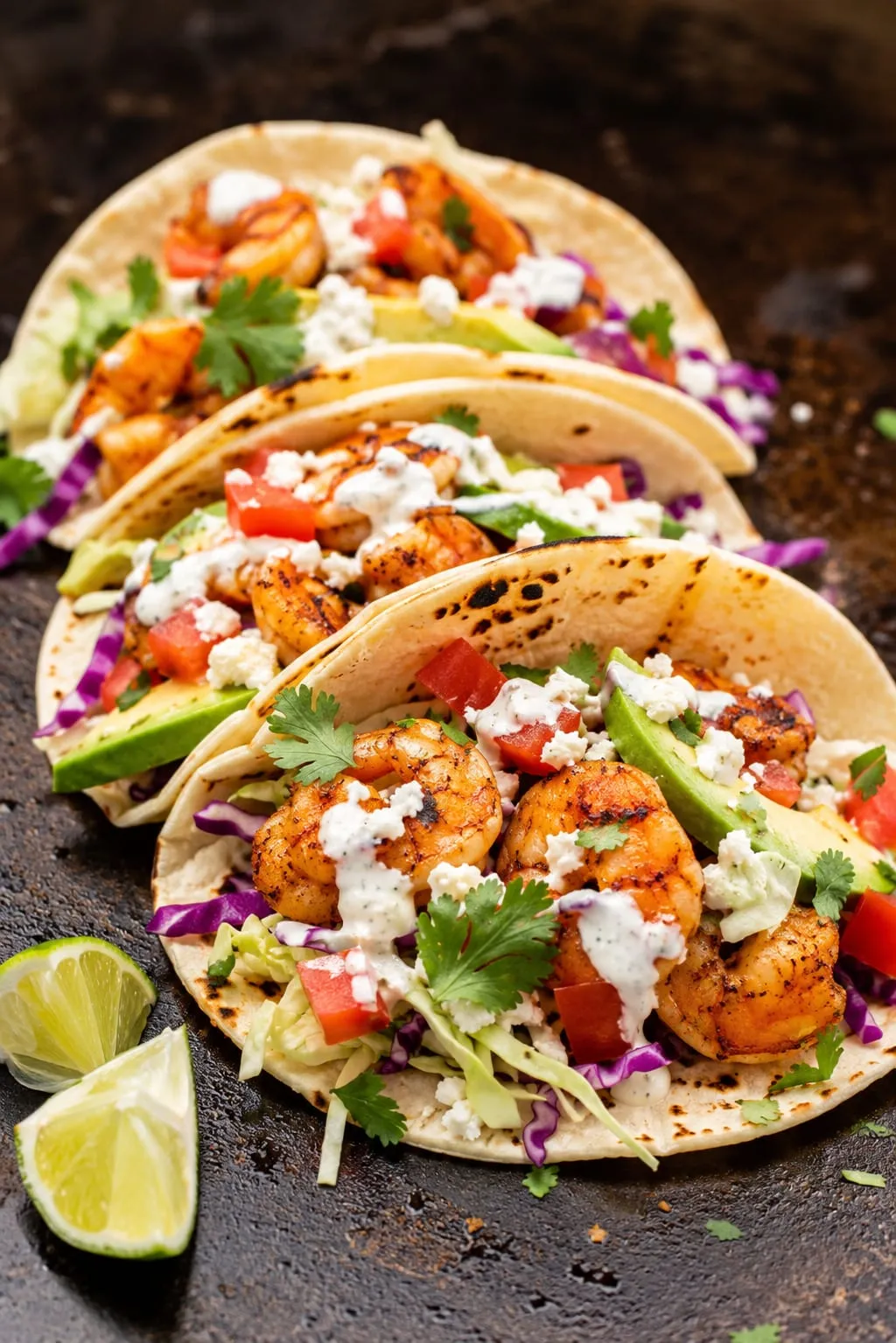 Blackstone shrimp tacos with seasoned shrimp, cabbage slaw, and lime on corn tortillas