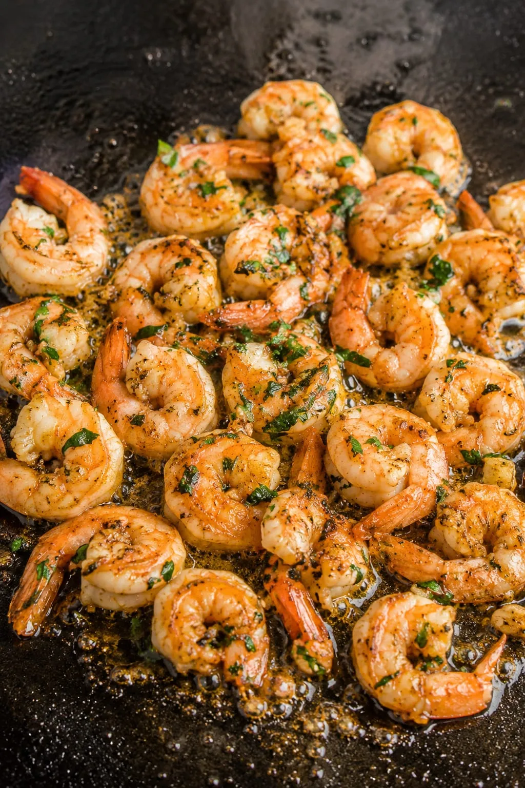 Blackstone shrimp with cilantro and lime on a dark plate